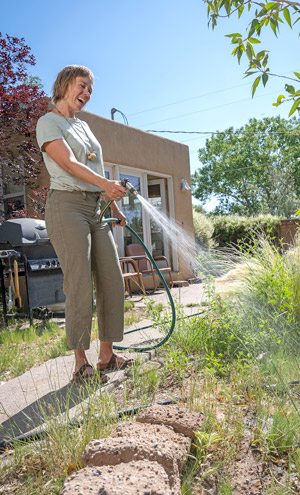 Erin watering her garden on her property in Santa Fe New Mexico.